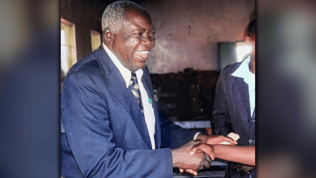 Pastor David Shikambi Luvai, smiling and shaking hands with someone during a church event in Kenya.